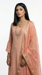 A stylish pose showing the complete pastel peach suit look, perfect for a sophisticated day event or office celebration.