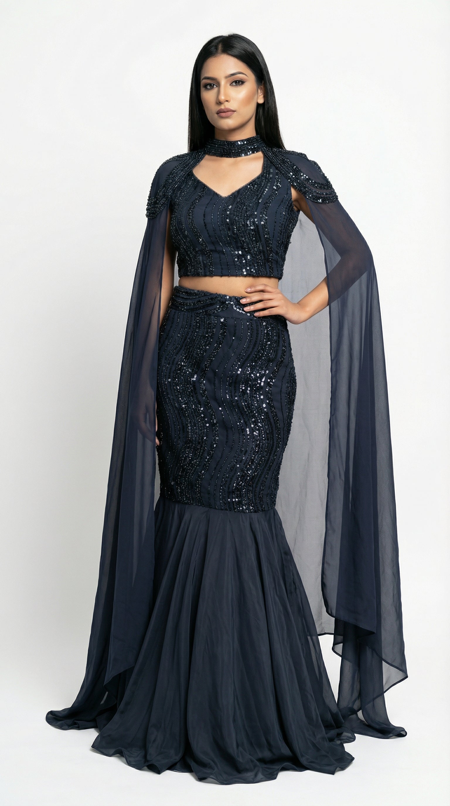 A sophisticated pose showing the sleek silhouette and dramatic cape of the navy blue mermaid lehenga set.