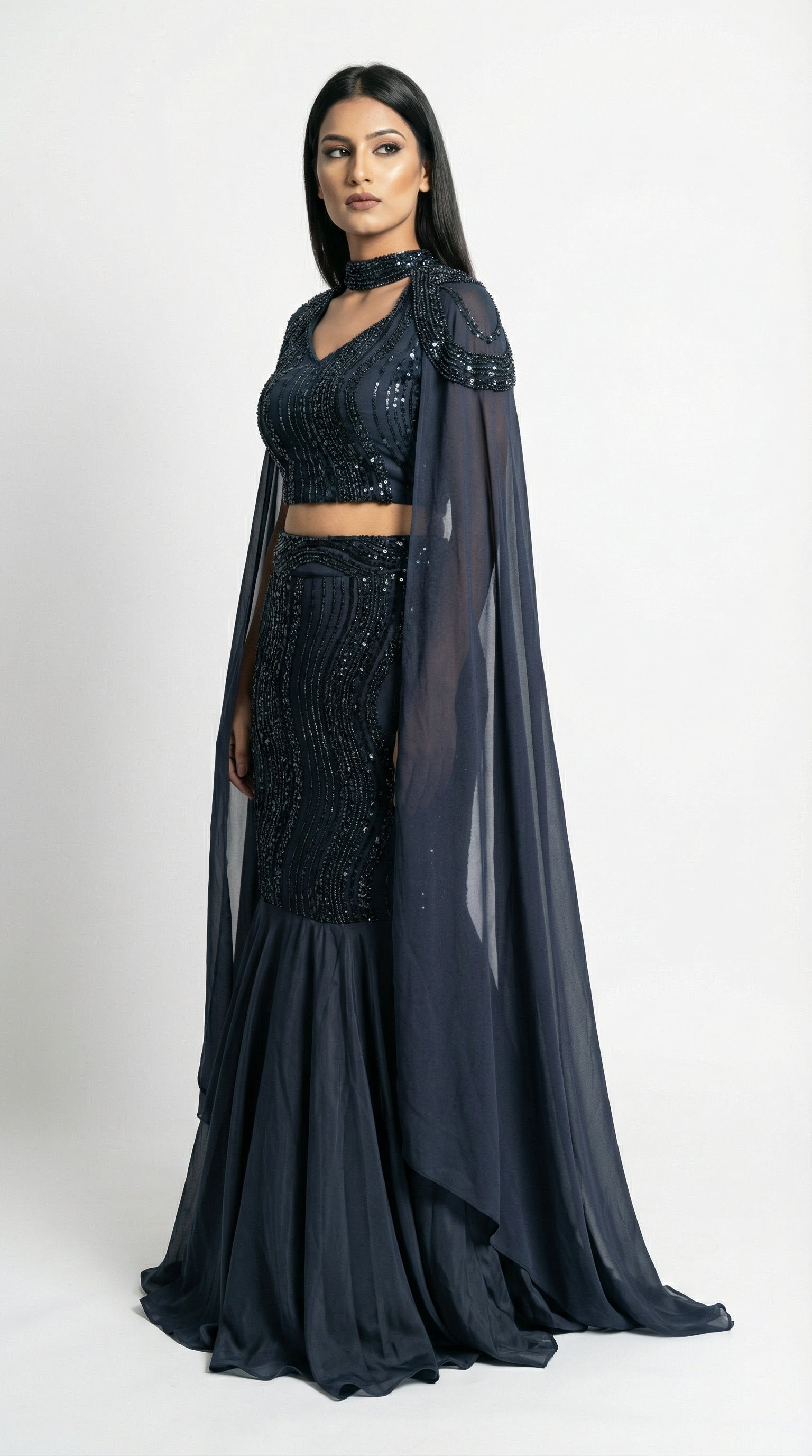 Close-up of the navy blue crop top showing the V-neckline, sequin beadwork, and shoulder attachment of the cape.
