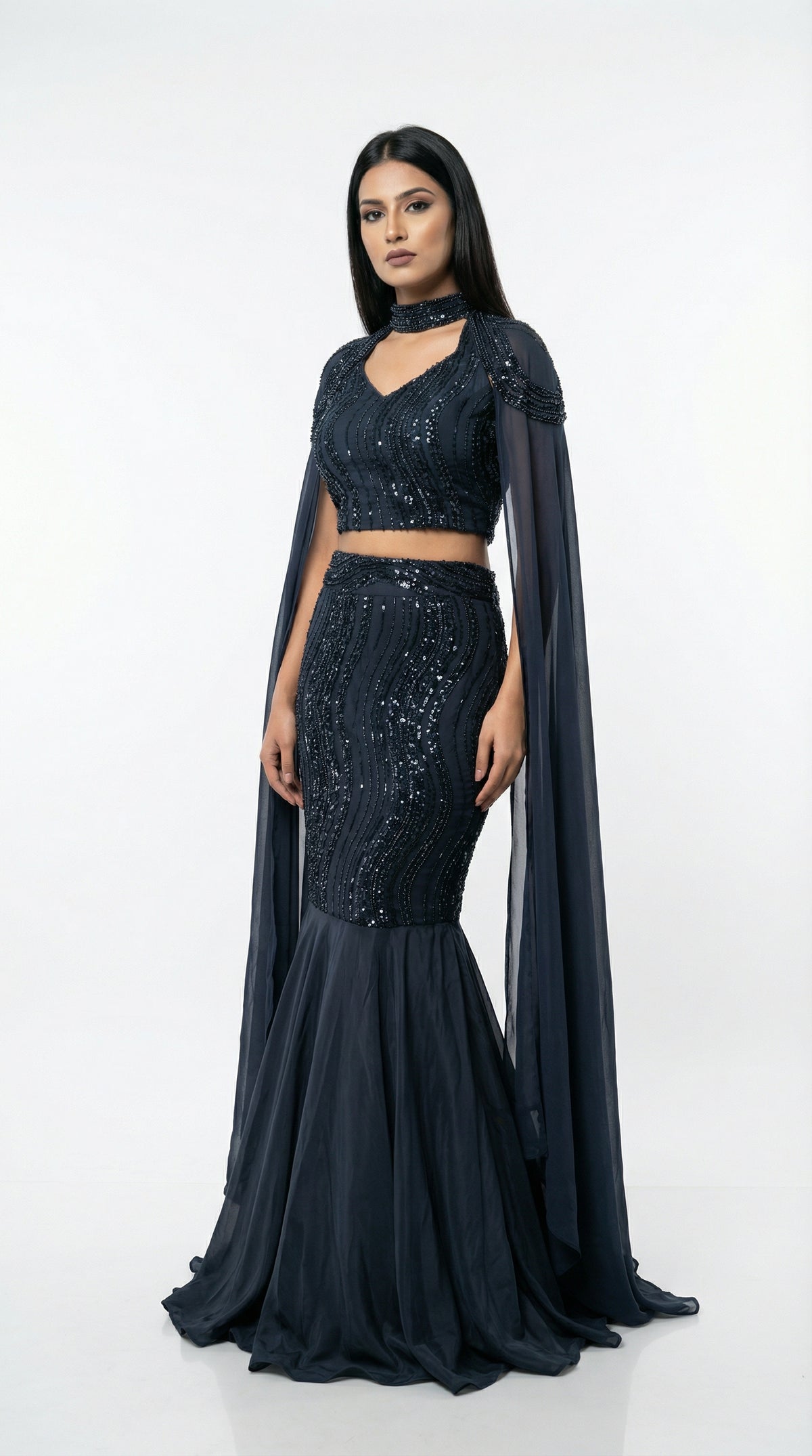 Detail of the fitted mermaid skirt showing the wave-patterned sequin embroidery and the flared hem.