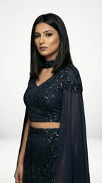 A sophisticated pose showing the sleek silhouette and dramatic cape of the navy blue mermaid lehenga set.