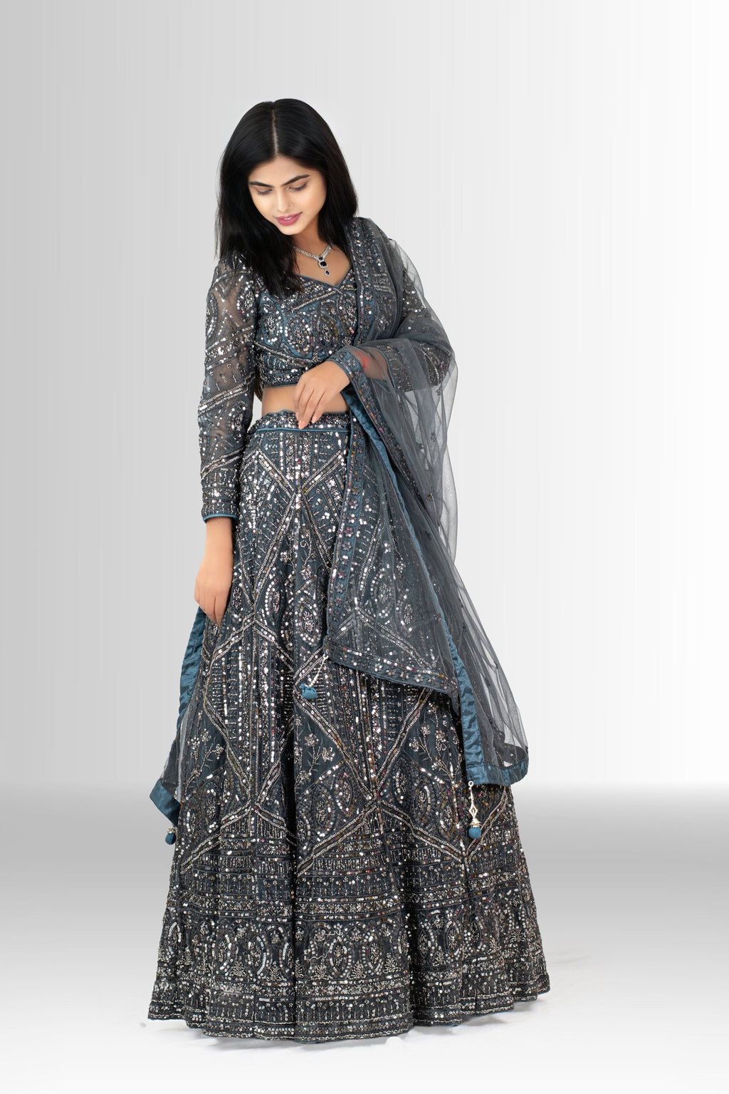 Model showcasing the sheer net dupatta with stylish blue and grey tassels, part of the Rosio House grey sequin lehenga set.