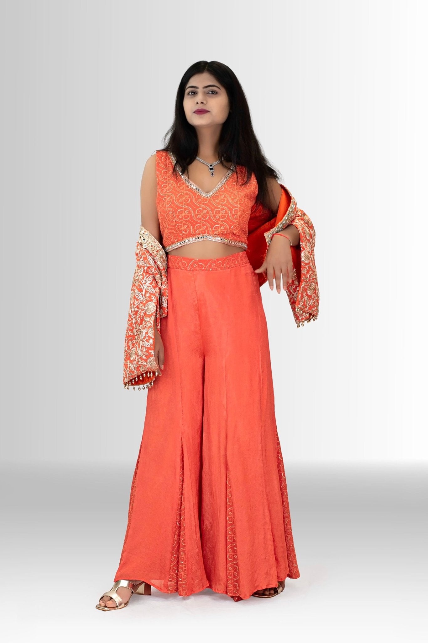 Model wearing the two-piece coral orange crop top indo western dress, a versatile and chic look for a festive occasion.