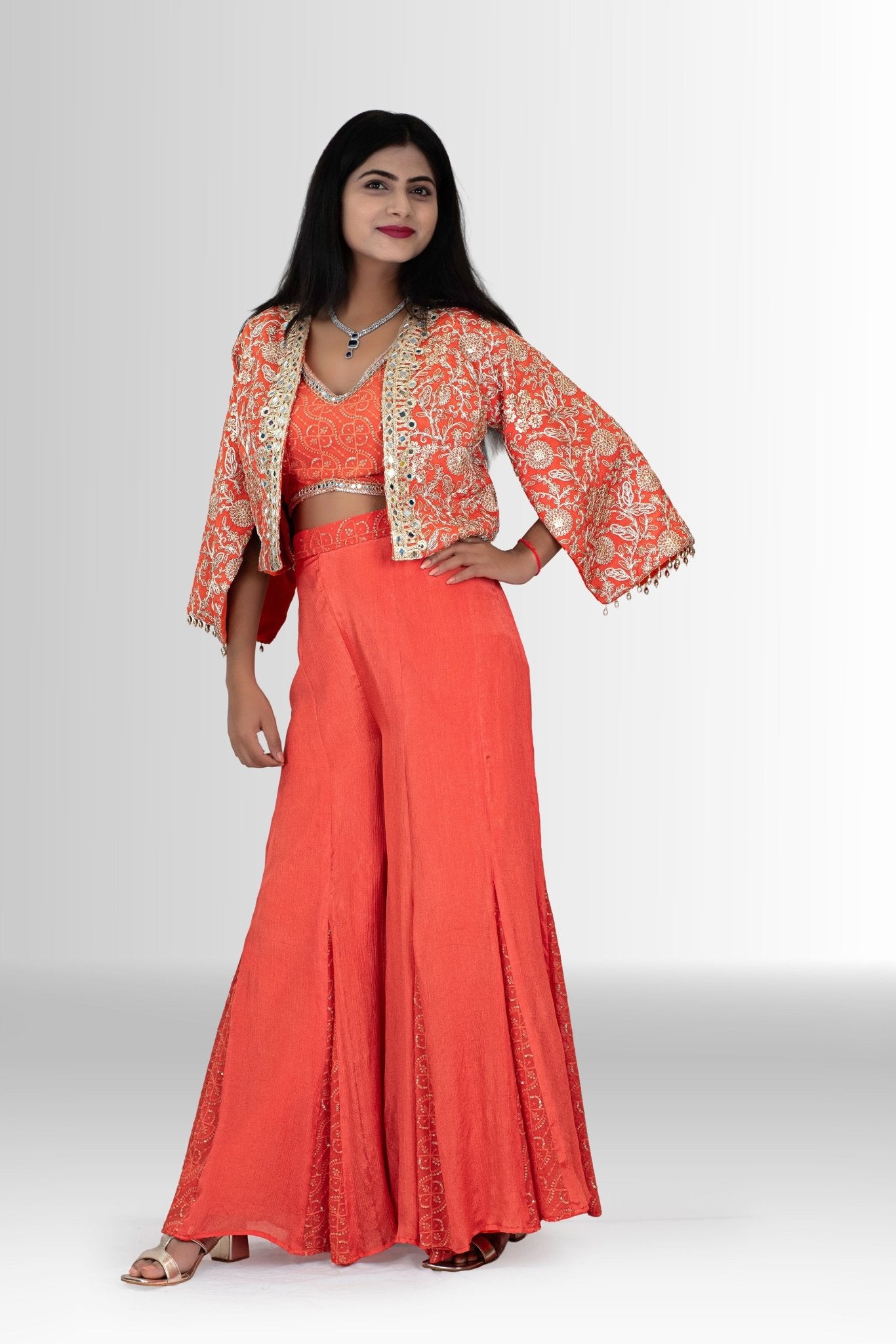 Detail shot of the flared chinon indowestern in coral orange, showing the texture and graceful movement of the fabric.