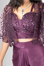 Close-up of a hand-embellished wine sequin bustier top and sheer net cape with flutter sleeves from the Rosio House party wear collection.