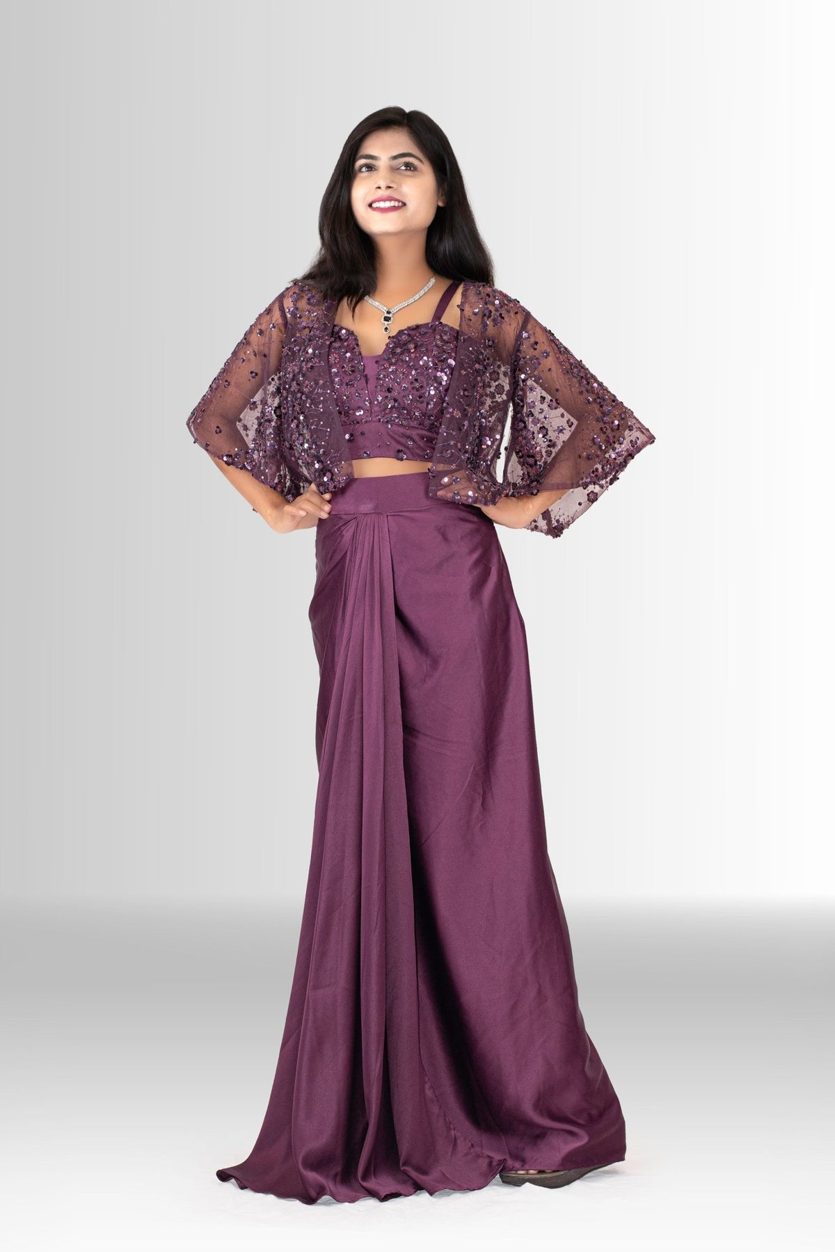 Model wearing the two-piece wine draped skirt and sequin bustier set without the cape, showing a versatile party look.