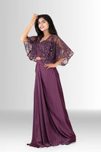 A woman twirling in a Rosio House wine-colored Indo-Western dress, showing the beautiful flow of the satin skirt and sheer flutter-sleeve cape.